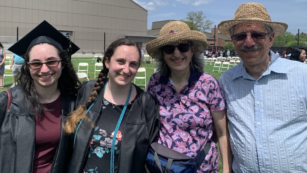 Ron smiles with his wife and two daughters at their graduation